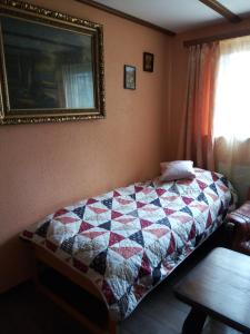 um quarto com uma cama com uma colcha em Gastzimmer für Übernachtung Гостевая комната em Oberbipp