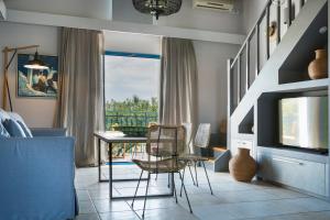 a living room with a table and chairs and a television at Avithos Resort Hotel in Svoronata
