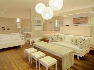 a living room with white couches and chairs and lights at Atlántico Boutique Hotel in Punta del Este