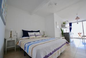 a bedroom with a bed with a blue and white comforter at Marine Lovers - Jacuzzi Fuerteventura in Gran Tarajal