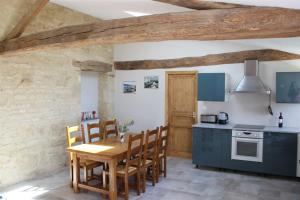 a kitchen with a wooden table and chairs in a room at La Bénetière in Saint-Valérien