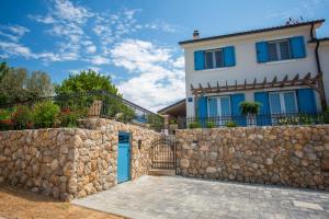 a house with a stone wall and a gate at Villa Tana in Sužan