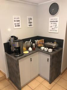 a kitchen with a counter with a coffee maker and a clock at Pensjonat Kasia i Michał in Szklarska Poręba