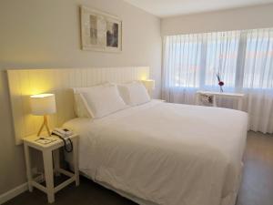 a bedroom with a large white bed and a window at Atlántico Boutique Hotel in Punta del Este