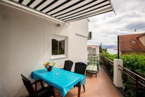 a patio with a blue table and chairs on a balcony at Mrkonjic Branko & Marija Apartmani in Omiš