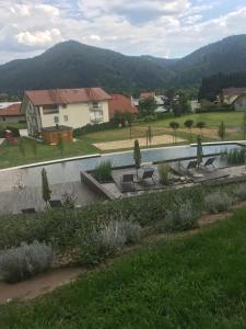 Blick auf einen Garten mit Stühlen und einem Pool in der Unterkunft Apartments & Wellness Skok in Mozirje