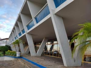 un edificio blanco con balcones azules junto a una palmera en Hotel Tijuco Turismo, en Diamantina
