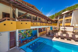 a view of the pool at a resort with a mural at Porto Cálem Praia Hotel in Porto Seguro