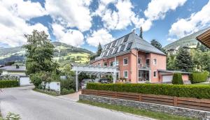 a pink house on a street with a fence at Apartment Hochpustertal in Heinfels
