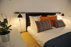 uma cama com almofadas laranja e branca e uma planta em Apartment Rudy em Zagreb