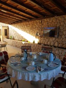 a table in a room with a stone wall at Apartments and Rooms Villa Mir in Zaton