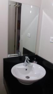 Un lavabo blanco sobre una encimera negra en un baño. en One Palm Tree Villas close to Manila Airport - Terminal 3, en Manila 8 fotos más