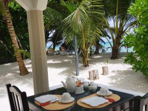 un tavolo con set per la preparazione del tè sulla spiaggia di Villa Admiral a Anse Possession
