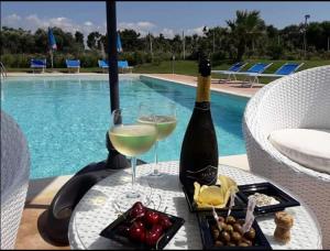 a table with two glasses of wine and a tray of food at Agliadò in Platamona