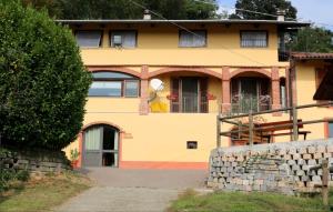 une maison jaune avec une clôture devant elle dans l'établissement La Bedina, à Rivara