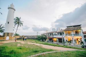 a lighthouse and a building next to a building at Antic Guesthouse - Galle Fort in Galle