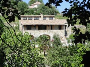 an old stone house in the middle of trees at Mas De Sarjac in Saint-Andéol-de-Vals