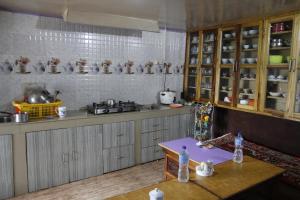 a kitchen with wooden cabinets and a table in it at Vamoose Chungdah Homestay in Pemayangtse