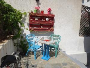 two blue chairs and a table in a patio at Amfi Apartments in Kardamaina