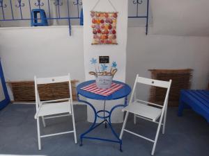 Amfi Apartments في كاردامينا: كرسيين وطاولة مع طاولة وكراسي زرقاء
