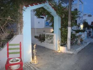 an archway with a red chair and lights at Amfi Apartments in Kardamaina