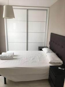 1 dormitorio con 1 cama blanca grande con lámpara en Apartamento Plaza del Socorro, en Ronda