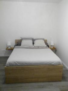 a bed in a room with two lamps on two tables at Le Jardin Ombragé in Saint-Paul-dʼIzeaux