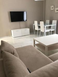 a living room with a couch and a table and a tv at Apartamento Plaza del Socorro in Ronda