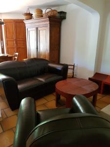 a living room with a leather couch and a table at Maison les Salles-sur-Verdon in Les Salles-sur-Verdon
