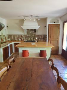 a dining room with a wooden table and a kitchen at Maison les Salles-sur-Verdon in Les Salles-sur-Verdon