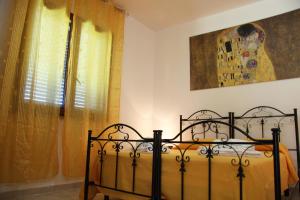 uma cama preta num quarto com uma janela em Il Casale di zio Marco em Torre Chianca