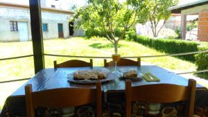 einen Tisch mit einem Teller Essen und einem Glas Wein in der Unterkunft Bakina kućica - Grandma's cottage in Gospić