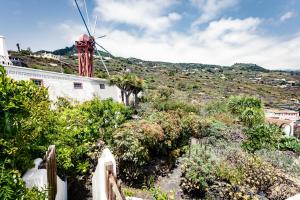 um moinho de vento ao lado de uma casa com uma colina em El Molino em Mazo