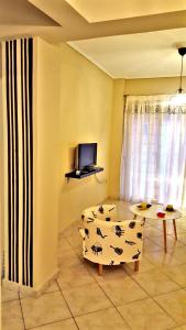 ein Wohnzimmer mit einem Sofa, einem Tisch und einem TV in der Unterkunft Cozy and minimal apartment in Piräus