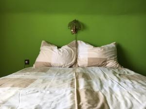 1 dormitorio con 1 cama con pared verde en Cs-Cs Vendégház, en Fonyód