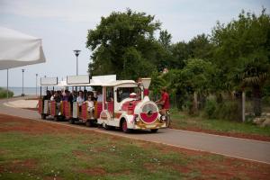 a small train full of people riding on a road at Apartment Vilma Funtana in Funtana