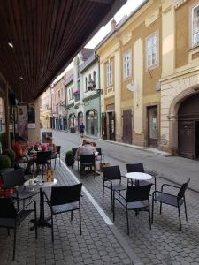 an empty street with tables and chairs and buildings at Mini Loft Apartman in Eger