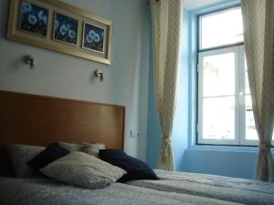 リスボンにあるBaixainnのベッドルーム1室(ベッド1台、大きな窓付)
