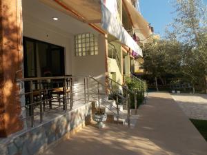 Un balcón de una casa con una mesa y sillas. en Elvin Apartments, en Sarandë
