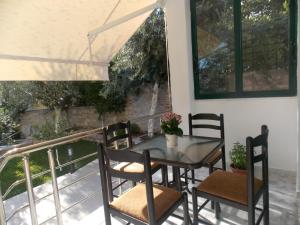 Una mesa de comedor y sillas en un balcón. en Elvin Apartments, en Sarandë 23 fotos más