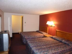 a hotel room with two beds and a television at Willow Springs Motel in Cheney