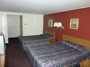 a hotel room with two beds and a television at Willow Springs Motel in Cheney