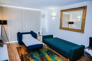 een woonkamer met een blauwe bank en een spiegel bij RIVERSIDE 2 BED APARTMENT in North Woolwich