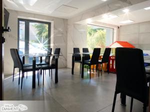 a dining room with black chairs and a table at Willa Diament in Karpacz