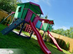 un parque infantil con un tobogán en el césped en Willa Diament en Karpacz