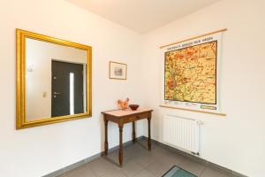 a mirror on a wall next to a table in a room at Ferienwohnung Mittendrin in Bergisch Gladbach