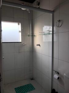 a bathroom with a shower with a glass door at Kitnet Central in Arraial do Cabo +13 photos