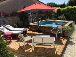 um deque com uma piscina, cadeiras e um guarda-sol em Saint James House em Pons