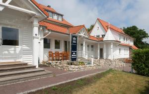 eine Reihe von weißen Häusern mit orangefarbenen Dächern in der Unterkunft Villa Godewind in Travemünde