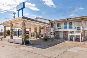 a building with a gas station in a parking lot at Studio 6 Fort Worth, TX - Stockyards East in Fort Worth